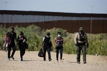 Lực lượng chức năng Mỹ bắt giữ người di cư bất hợp pháp vượt biên từ Mexico vào Mỹ tại Yuma, bang Arizona, ngày 12/5/2021. (Ảnh: AFP/TTXVN)