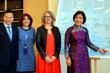 Đại sứ Lê Thị Tuyết Mai, Trưởng Phái đoàn Việt Nam tại Geneva ký tên vào tấm áp-phích Hiến chương Liên hợp quốc. (Ảnh: TTXVN)