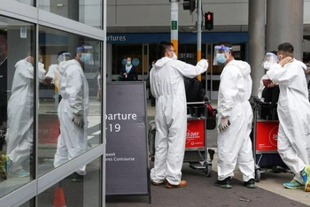 Du khách mặc thiết bị bảo hộ cá nhân khi tới sân bay quốc tế Sydney trong bối cảnh Australia ứng phó làn sóng Omicron, ngày 29/11/2021. (Ảnh: Reuters)