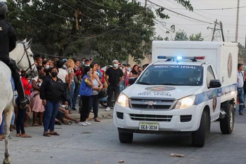 Gia đình của tù nhân chờ đợi tin tức của người thân trong lúc xe chở nhân viên pháp y tới nhà tù Guayas 1, ở thành phố Guayaquil, ngày 5/10. (Ảnh: Reuters)