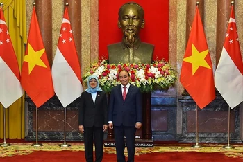 Chủ tịch nước Nguyễn Xuân Phúc và Tổng thống Singapore Halimah Yacob chụp ảnh chung tại lễ đón. (Ảnh: Thủy Nguyên)