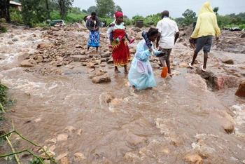Người dân tại Blantyre, Malawi đi qua con đường bị ngập do bão Freddy. (Ảnh: Reuters)