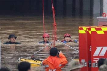 Lực lượng cứu hộ nỗ lực rút nước và tìm kiếm tại đường hầm bị ngập. (Ảnh: Reuters)