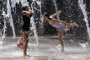 Các bé gái "giải nhiệt" trong thời tiết nắng nóng tại bang Texas, Mỹ, ngày 18/7/2023. (Ảnh: Reuters)