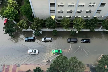 Một khu dân cư trên đường Nguyễn Lương Bằng (Quận 7) bị “biển nước” bao quanh do mưa lớn và triều cường. (Ảnh: TTXVN) 