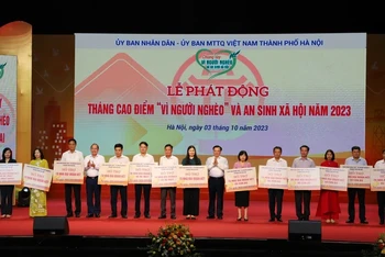 Bí thư Thành ủy Hà Nội Đinh Tiến Dũng và Phó Chủ tịch Ủy ban Mặt trận Tổ quốc Việt Nam Hoàng Công Thủy trao kinh phí hỗ trợ hộ nghèo cho các huyện, thị xã của Hà Nội.