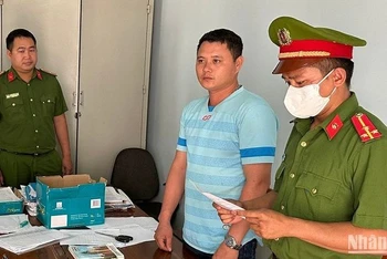 Công an huyện Đắk Mil tống đạt các quyết định tố tụng đối với Nguyễn Thành Trung (mặc áo thun xanh sọc ngang).