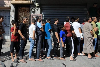 Người dân xếp hàng chờ mua thực phẩm tại miền nam Dải Gaza. (Ảnh: THX/TTXVN)