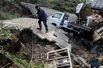 Anh Masatoshi Nakamae đi qua tuyến đường bị hư hại tại thành phố Wajima, tỉnh Ishikawa, sau trận động đất ngày 1/1/2024. (Ảnh: REUTERS)