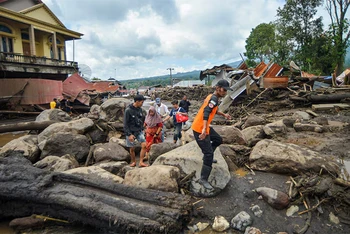 Người dân địa phương đi qua khu vực chịu ảnh hưởng của mưa lớn. (Ảnh: Reuters)