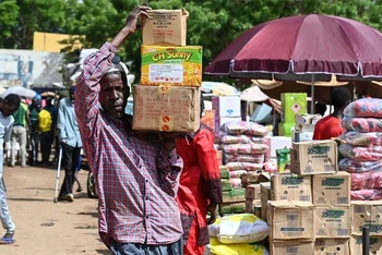 Người dân chuyển lương thực tại khu chợ ở Niamey (Niger). (Ảnh: AFP/TTXVN)