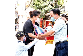 Lãnh đạo phường Dịch Vọng Hậu, quận Cầu Giấy trao quà hỗ trợ người dân có hoàn cảnh khó khăn trong đợt dịch Covid-19. (Ảnh DUY LINH)