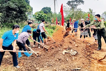 Cán bộ các cơ quan tỉnh Tuyên Quang tham gia san gạt, đắp lề đường cùng nhân dân thôn Mỏ Nghiều 2, xã Tân Thành, huyện Hàm Yên.