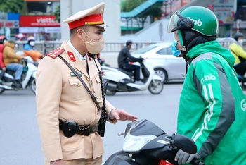 Cảnh sát giao thông Hà Nội nhắc nhở lái xe công nghệ chấp hành nghiêm Luật Giao thông đường bộ. (ảnh HUY HOÀNG)