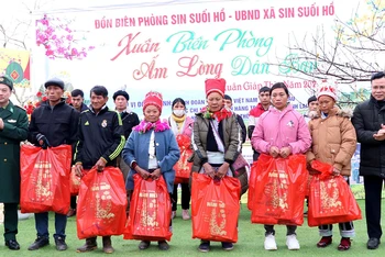 Ðại diện lãnh đạo Bộ đội Biên phòng tỉnh Lai Châu và huyện Phong Thổ trao quà tặng các hộ nghèo ở bản Chí Sáng, xã Sin Suối Hồ, huyện Phong Thổ. (Ảnh ÐỨC DUẨN)