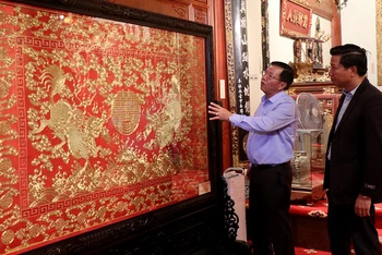 Ông Nguyễn Thế Hồng giới thiệu với du khách Tranh thêu chỉ vàng thời Nguyễn trưng bày trong Bảo tàng Hoàng gia Nam Hồng.