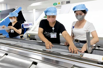 Công nhân lao động tại Nhà máy dệt Top Textile - doanh nghiệp 100% vốn trực tiếp nước ngoài tại Khu công nghiệp Rạng Ðông, huyện Nghĩa Hưng, tỉnh Nam Ðịnh. 
