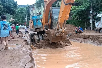 Lực lượng chức năng san gạt bùn đất do lũ quét để sớm thông quốc lộ 7, đoạn qua thị trấn Mường Xén (Kỳ Sơn).
