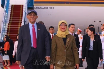 Tổng thống Cộng hòa Singapore Halimah Yacob và Phu quân tại Sân bay Quốc tế Nội Bài, Hà Nội. (Ảnh: Văn Điệp - TTXVN)
