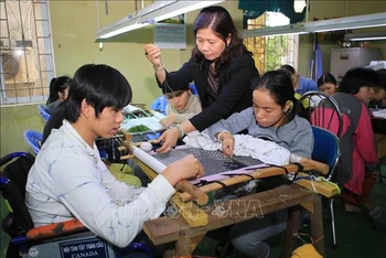 Học viên khuyết tật học nghề thêu tại Trung tâm Dạy nghề và đào tạo việc làm cho người khuyết tật tỉnh Thừa Thiên Huế (Ảnh minh hoạ: Hồ Cầu/TTXVN)