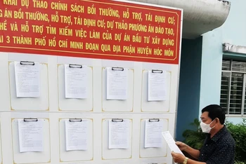 Người dân xã Xuân Thới Thượng, huyện Hóc Môn, Thành phố Hồ Chí Minh xem thông tin niêm yết về chính sách đền bù dự án Vành đai 3.