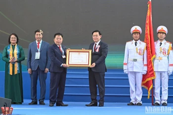 Chủ tịch Quốc hội Vương Đình Huệ trao Huân chương Lao động hạng Nhất cho Học viện Tài chính. (Ảnh: DUY LINH)