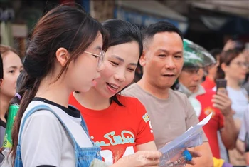 Thí sinh, phụ huynh xem đề thi sau buổi thi Ngữ văn, kỳ thi tuyển sinh vào lớp 10 tại Hà Nội (Ảnh: HOÀNG HIẾU/TTXVN)