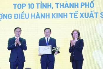 Chủ tịch Ủy ban nhân dân tỉnh Bắc Giang Lê Ánh Dương (giữa) nhận kỷ niệm chương dành cho 10 tỉnh, thành phố xuất sắc nhất cả nước về thực hiện PCI năm 2022.