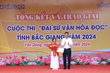 Ông Nguyễn Sỹ Cầm, Phó Giám đốc sở Văn hóa, Thể thao và Du lịch trao giải “Đại sứ Văn hóa đọc tiêu biểu xuất sắc” tỉnh Bắc Giang năm 2024 cho em Lưu Minh Anh, lớp 10A1, Trường THPT Yên Dũng số 3.