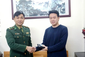 Thiếu tá Phùng Văn Yên trao trả tài sản cho anh Lê Việt Hùng, ở phường Kim Tân, thành phố Lào Cai. (Ảnh: QUỐC HỒNG)