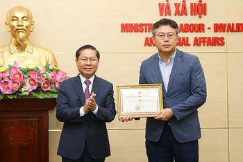 Thứ trưởng Lê Tấn Dũng trao Kỷ niệm chương cho ông Kang Byung Joo (Ảnh: Molisa).