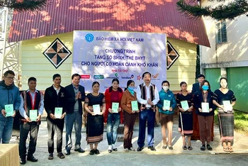 Đại diện Bảo hiểm xã hội Việt Nam trao tặng sổ bảo hiểm xã hội, thẻ bảo hiểm y tế cho người dân khó khăn ở làng Ia Nueng, xã Biển Hồ, thành phố Pleiku, tháng 12/2022 (Ảnh: Hà Ly)