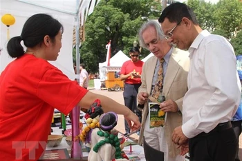 Đại sứ Việt Nam tại Argentina và Thứ trưởng Ngoại giao nước chủ nhà Pablo Tettamanti thăm gian hàng Việt Nam tại hội chợ. (Ảnh: TTXVN)