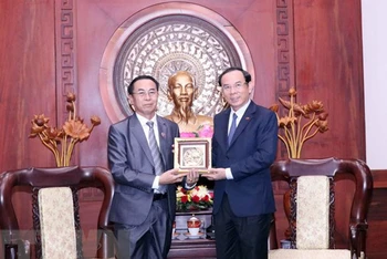 Bí thư Thành ủy Thành phố Hồ Chí Minh Nguyễn Văn Nên trao tặng phẩm lưu niệm cho ông Khampheng Vilaphanh. (Ảnh: TTXVN)