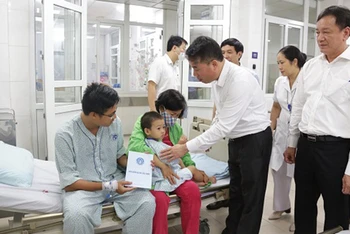 Tổng Giám đốc Bảo hiểm xã hội Việt Nam Nguyễn Thế Mạnh thăm hỏi, trao hỗ trợ người bị thương trong vụ cháy chung cư mini tại Khương Hạ, quận Thanh Xuân, Hà Nội. (Ảnh: Tâm Trung)