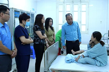Đại diện Quỹ Bảo trợ trẻ em Việt Nam thăm hỏi, tặng quà cho trẻ em bị thương trong vụ cháy đang điều trị tại bệnh viện. (Ảnh: NFVC)