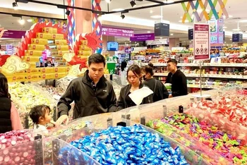 Người tiêu dùng mua bánh kẹo Tết tại siêu thị Aeon Long Biên. (Ảnh: NGUYÊN TRANG)