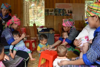 Phụ nữ xã La Pán Tẩn, huyện Mù Cang Chải, Yên Bái, chăm sóc bữa ăn cho trẻ em người H’Mông. (Ảnh: THANH SƠN)