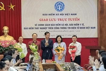 Phó Tổng Giám đốc Bảo hiểm xã hội Việt Nam Đào Việt Ánh tặng hoa khách mời, chuyên gia tham dự giao lưu trực tuyến vào tháng 11/2023. (Ảnh: TÂM TRUNG)
