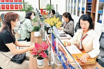 Người dân thực hiện giải quyết thủ tục hành chính tại Bộ phận một cửa quận Đống Đa, Hà Nội. (Ảnh minh họa: NGUYÊN BẢO)