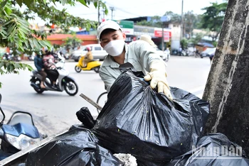 Thành viên nhóm Hà Nội Xanh dọn rác tại khu vực cầu Mậu Lương, quận Hà Đông, thành phố Hà Nội. (Ảnh MỸ HÀ) 