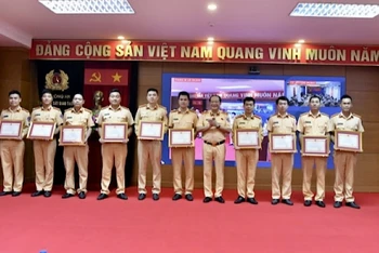 Cán bộ, chiến sĩ tăng cường công tác đăng kiểm nhận bằng khen của Cục Cảnh sát giao thông.