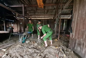 Công an huyện Than Uyên (Lai Châu) giúp dân xúc bỏ bùn đất tràn vào nhà tại bản Hô Ta, xã Tà Mung.