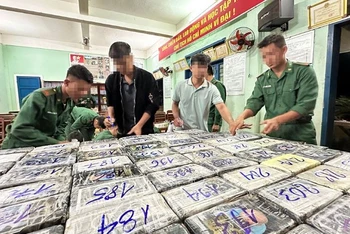 Lực lượng chức năng giám định 300 gói nghi ma túy trôi dạt tại bờ biển gành Nước Nhỉ, thôn Phước Thiện, xã Bình Hải, huyện Bình Sơn. (Ảnh: Thành Long)