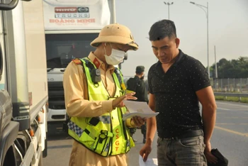 Cảnh sát giao thông tuyên truyền, hướng dẫn tài xế điều khiển các phương tiện bị cấm tại các nút giao ra, vào tuyến Cam Lộ-La Sơn.