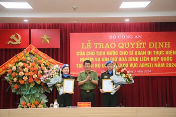 Thượng tướng Lương Tam Quang trao quyết định cho Thiếu tá Vũ Trần Thắng và Đại úy Nguyễn Lan Anh.