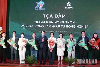 Ban Tổ chức tặng hoa cho các đại biểu, thanh niên nhận giải thưởng Lương Định Của điển hình qua các thời kỳ tham gia tọa đàm.