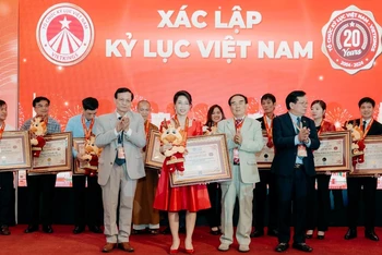 Đại diện Sconnect (váy đỏ) nhận hai chứng nhận kỷ lục Việt Nam. (Ảnh: Bảo Châu)