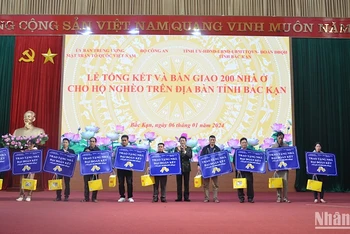 Thượng tướng Lương Tam Quang, Thứ trưởng Công an trao chìa khoá tượng trưng cho 10 hộ dân được hỗ trợ nhà. (Ảnh: TUẤN SƠN)
