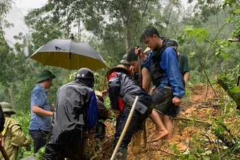 Người dân đào bới cứu 2 nạn nhân bị vùi lấp do sạt lở trên đường Côn Minh-Vũ Muộn. (Ảnh: VĂN THIỀU)